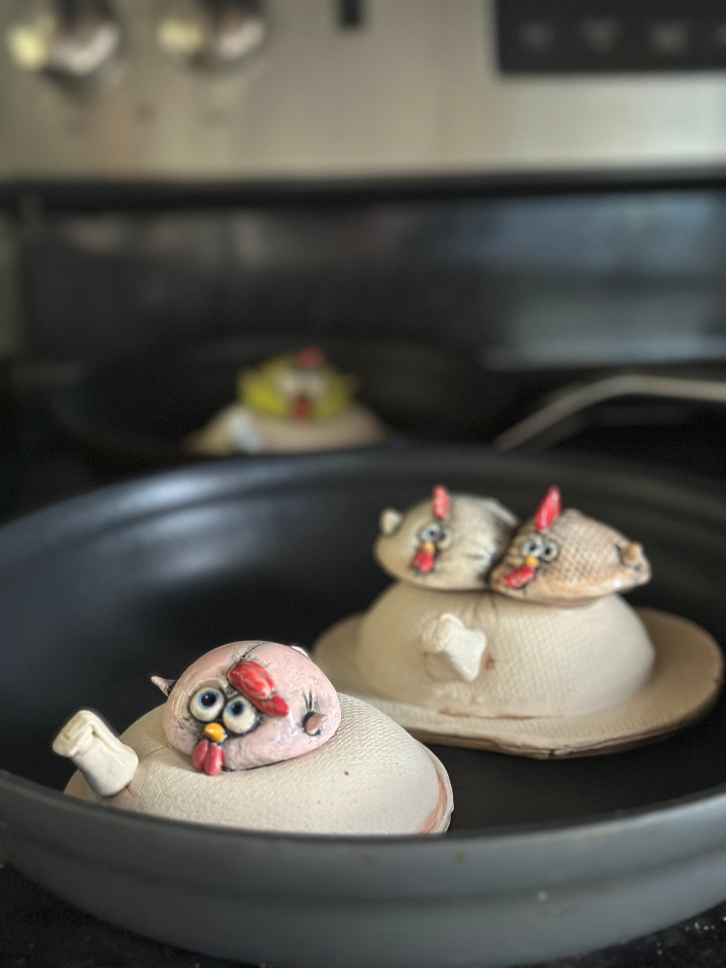 Ceramic chicks in pan on stove