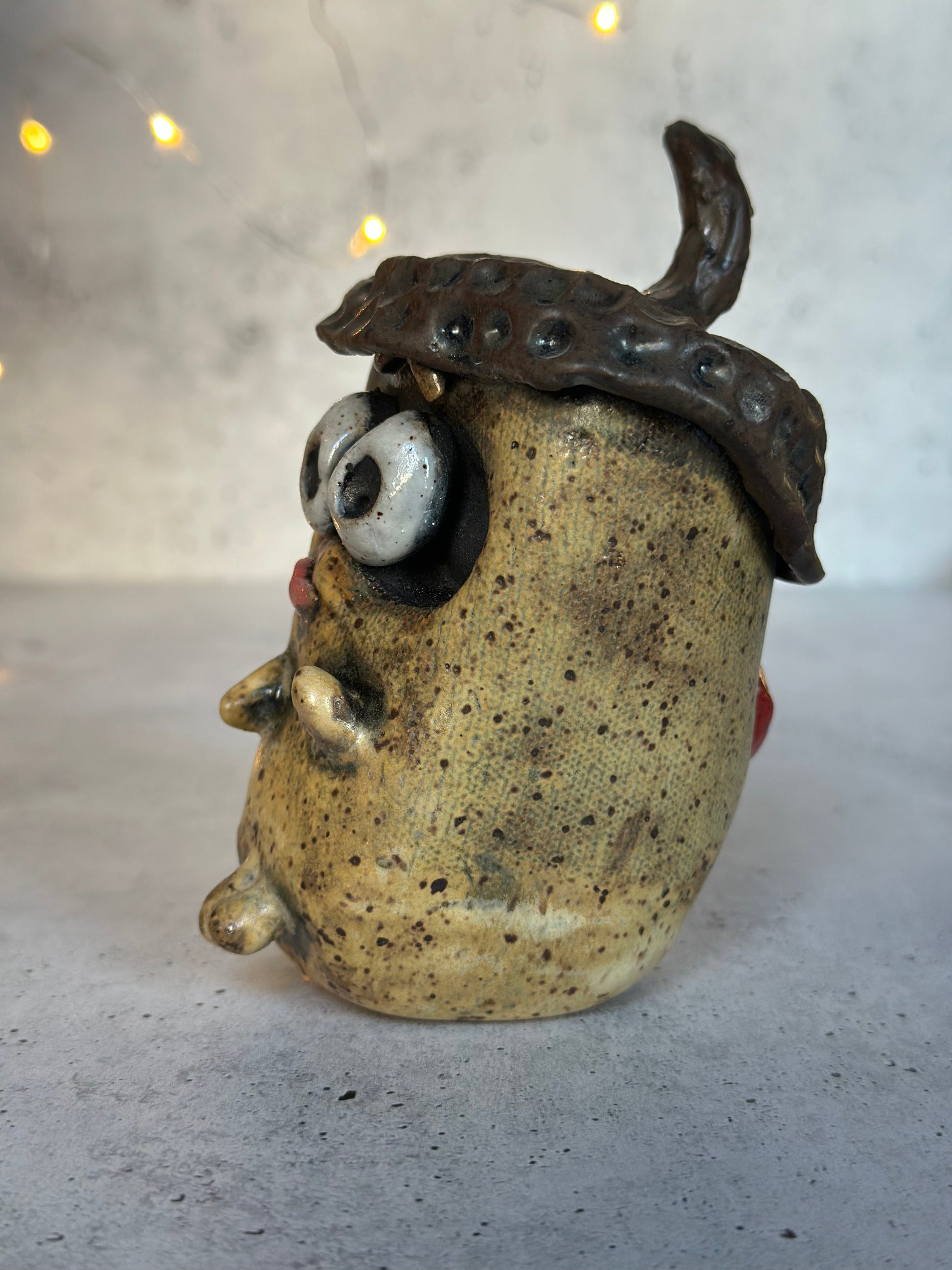 Ceramic acorn head with a textured surface on a gray background