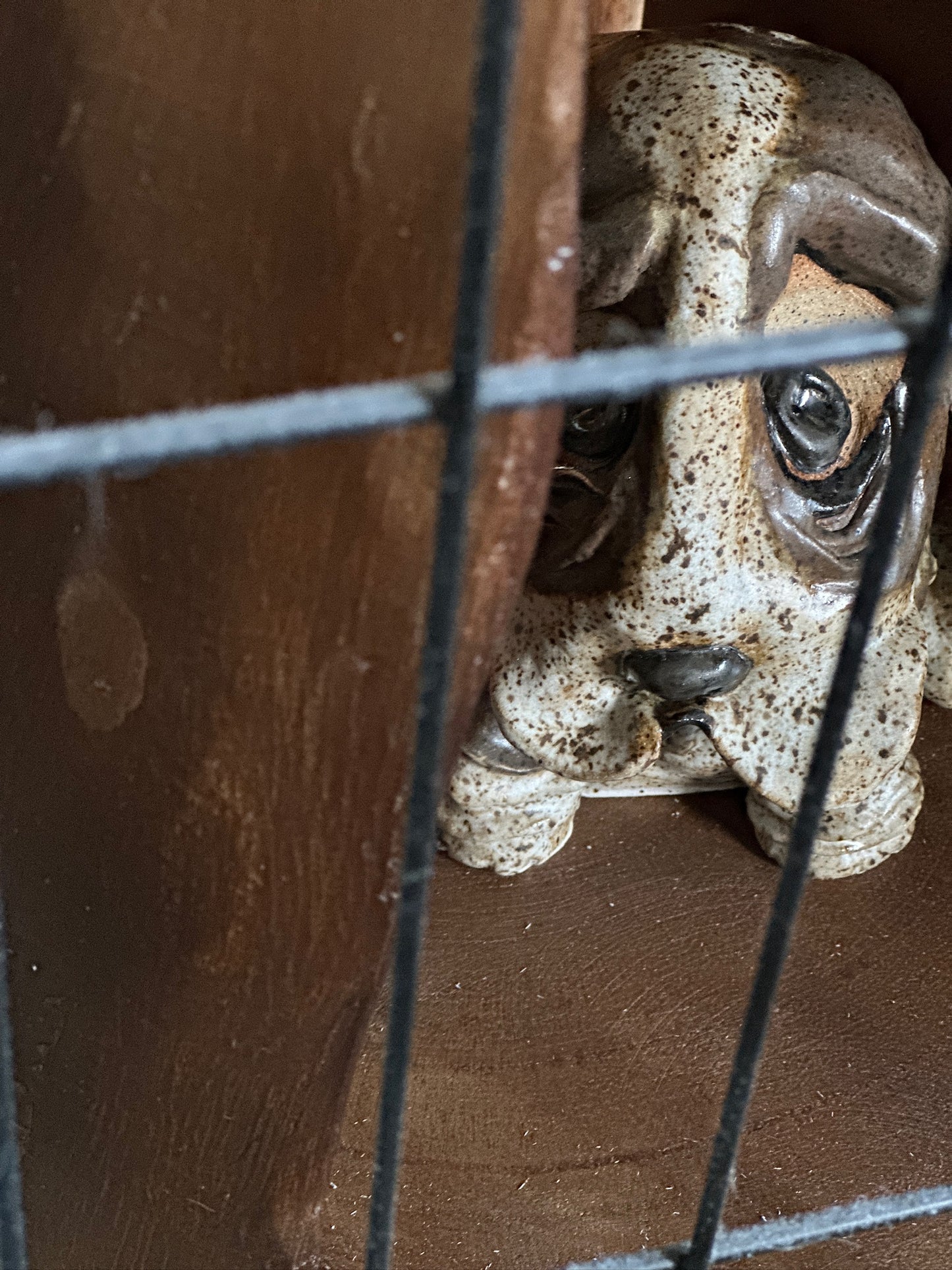 Ceramic dog sculpture behind a crate