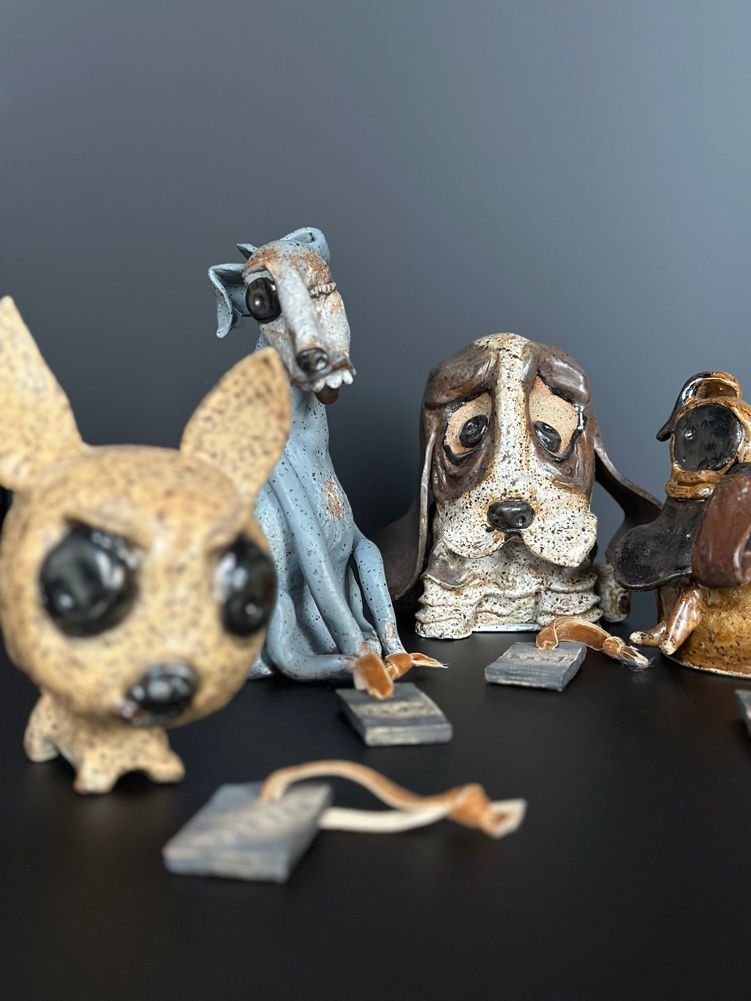Collection of dog-themed figurines on a dark surface with a gray background