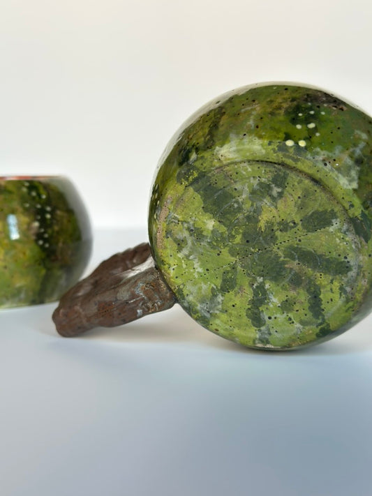 Green ceramic ring with brown band on a white background