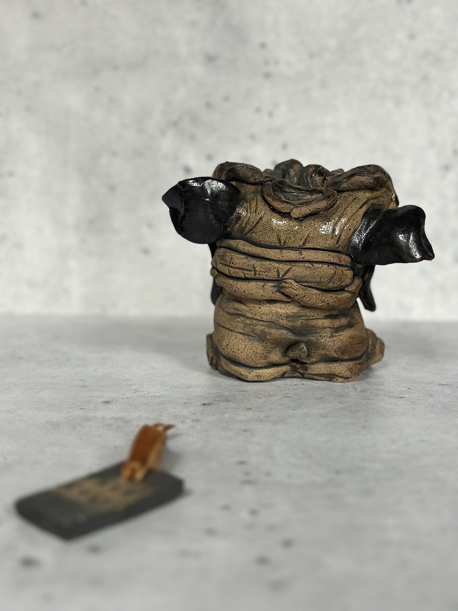 Small figurine of a pug sculpture on a textured surface