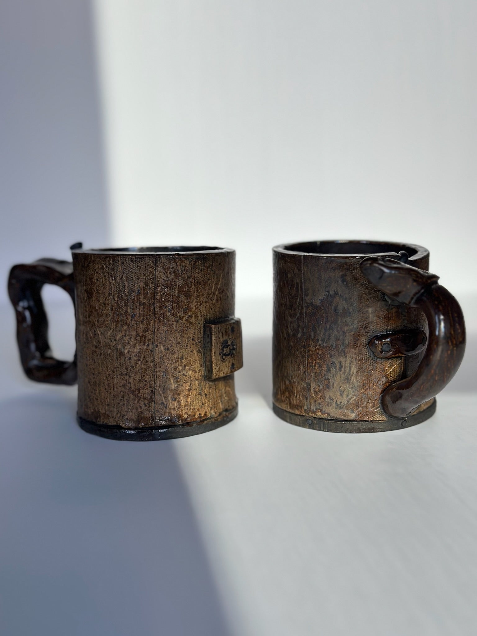 Two rustic ceramic mugs on a white background