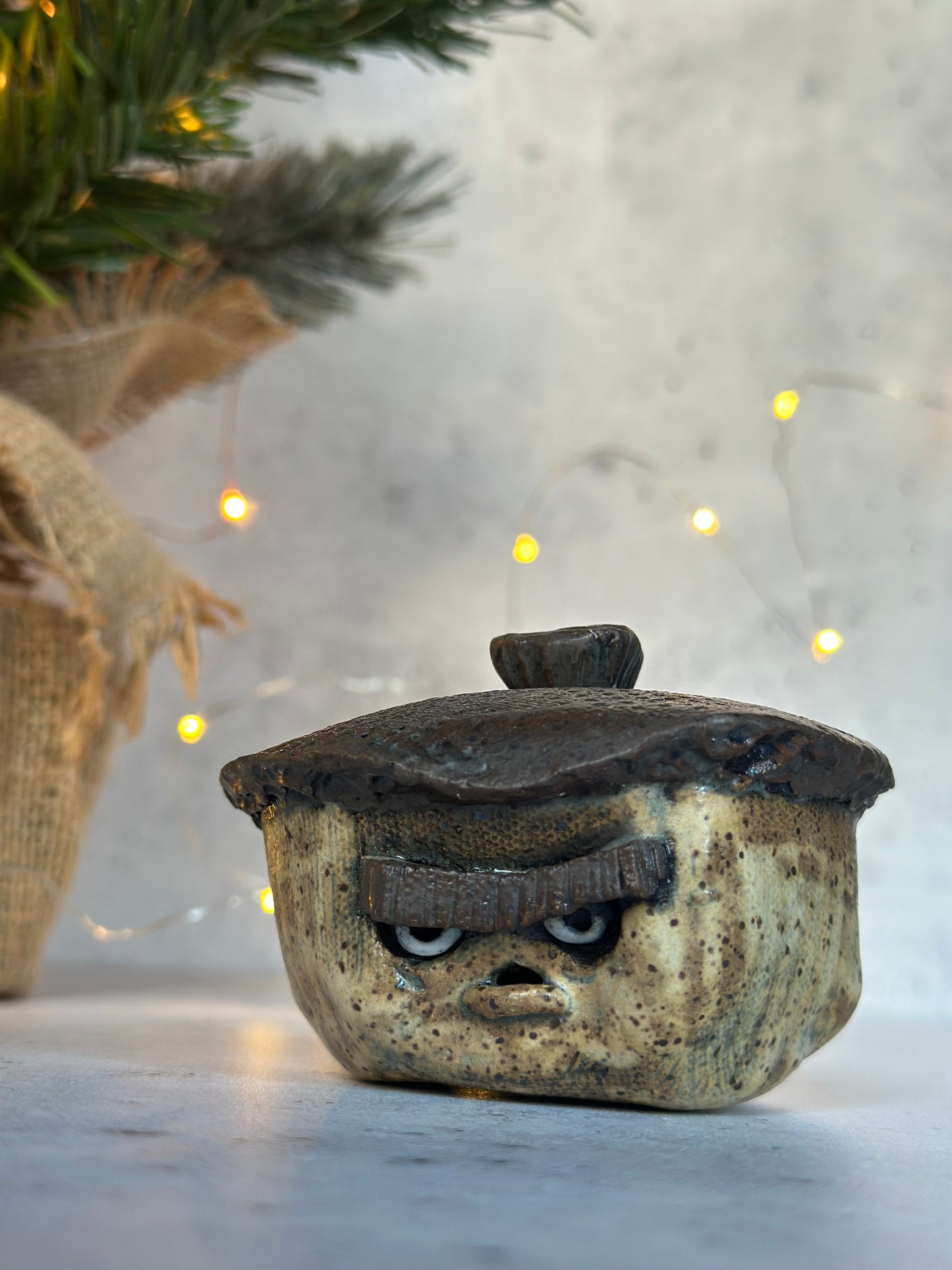 Decorative ceramic acorn with face design on a neutral background