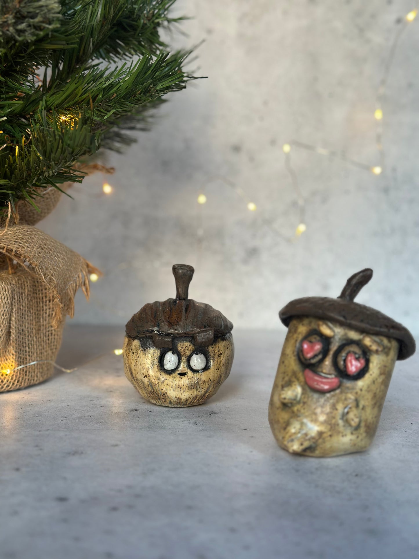 Two acorns with face details on a neutral background