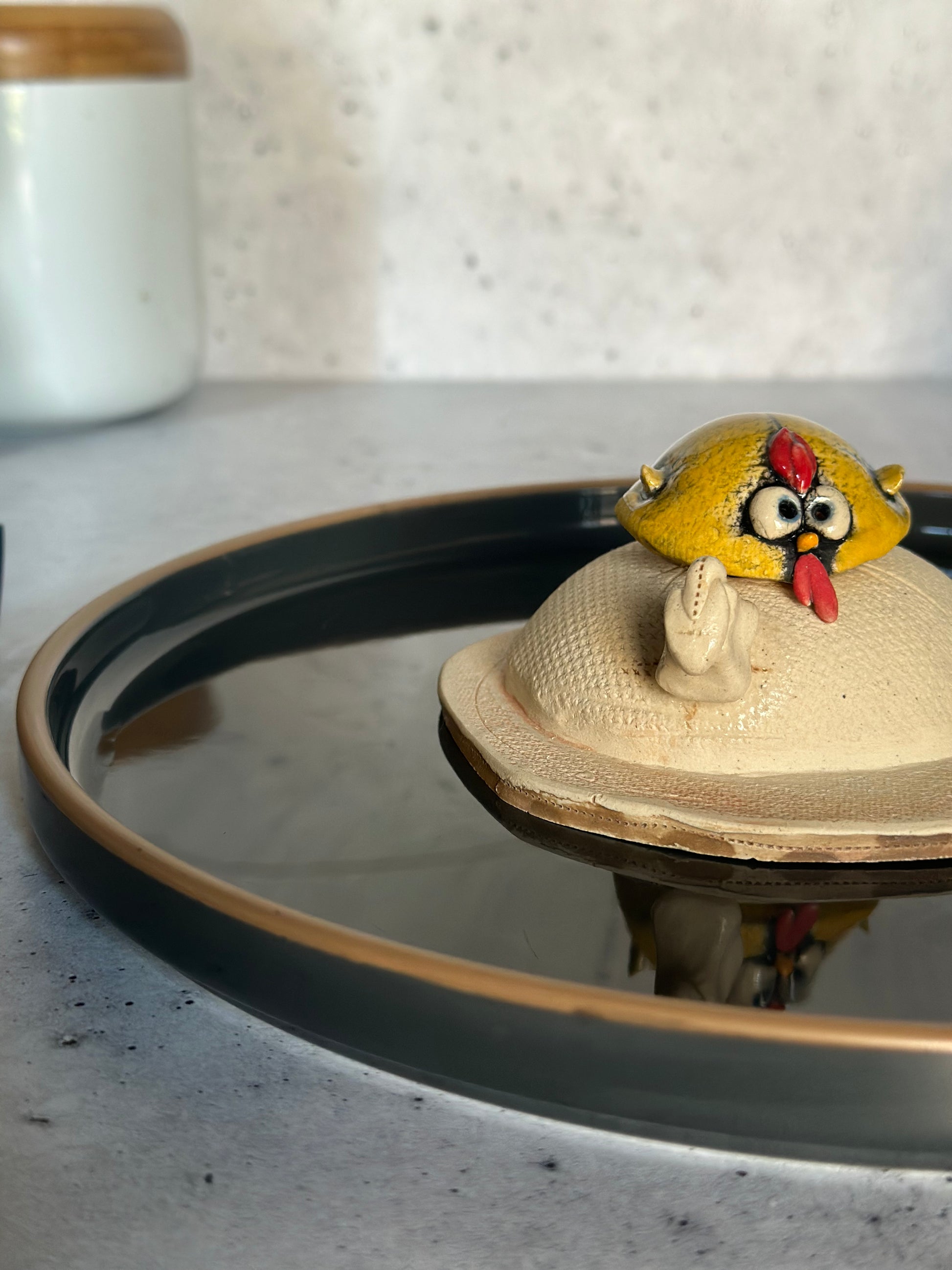 Ceramic egg with a yellow bird figurine on a stone surface