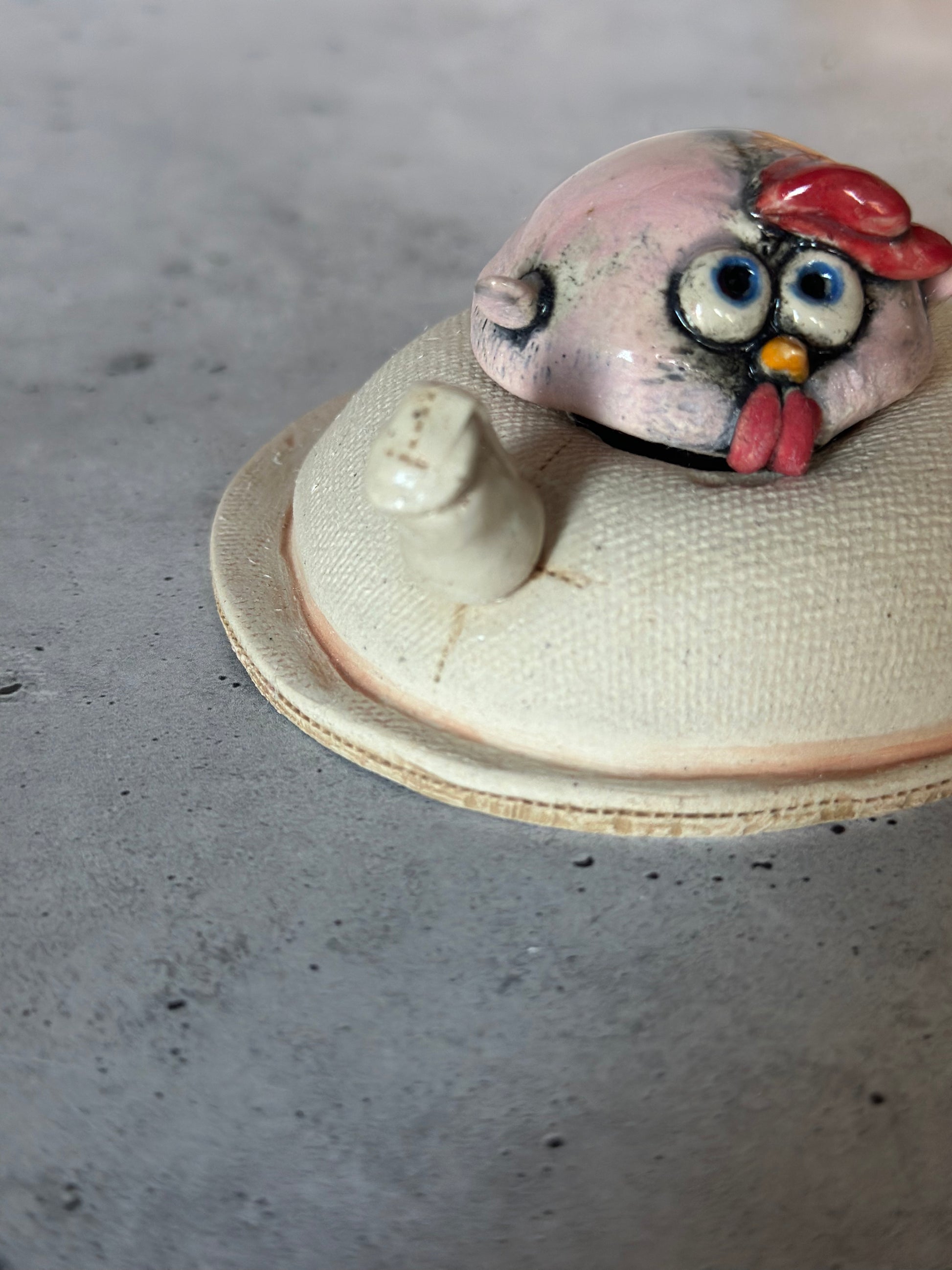 Ceramic chick figurine on a concrete surface
