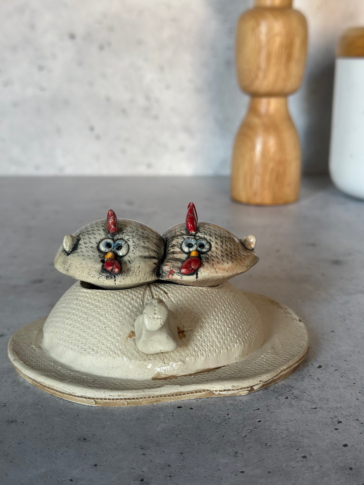 Ceramic chicken on egg on a gray surface