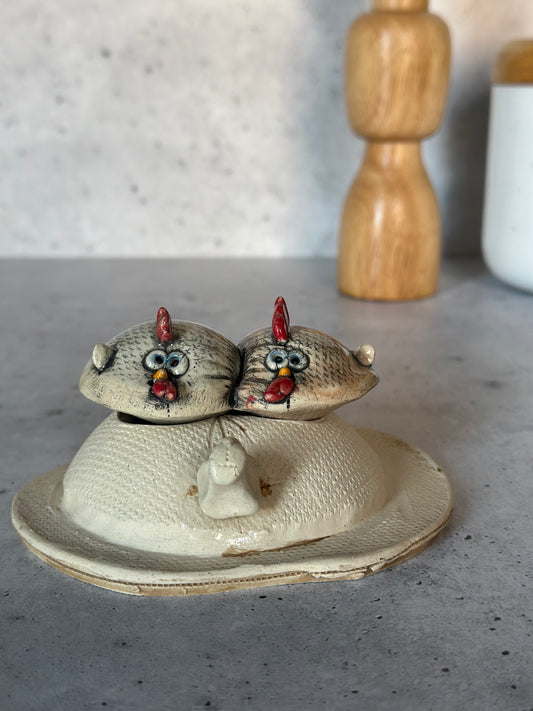 Ceramic chicken on egg on a gray surface