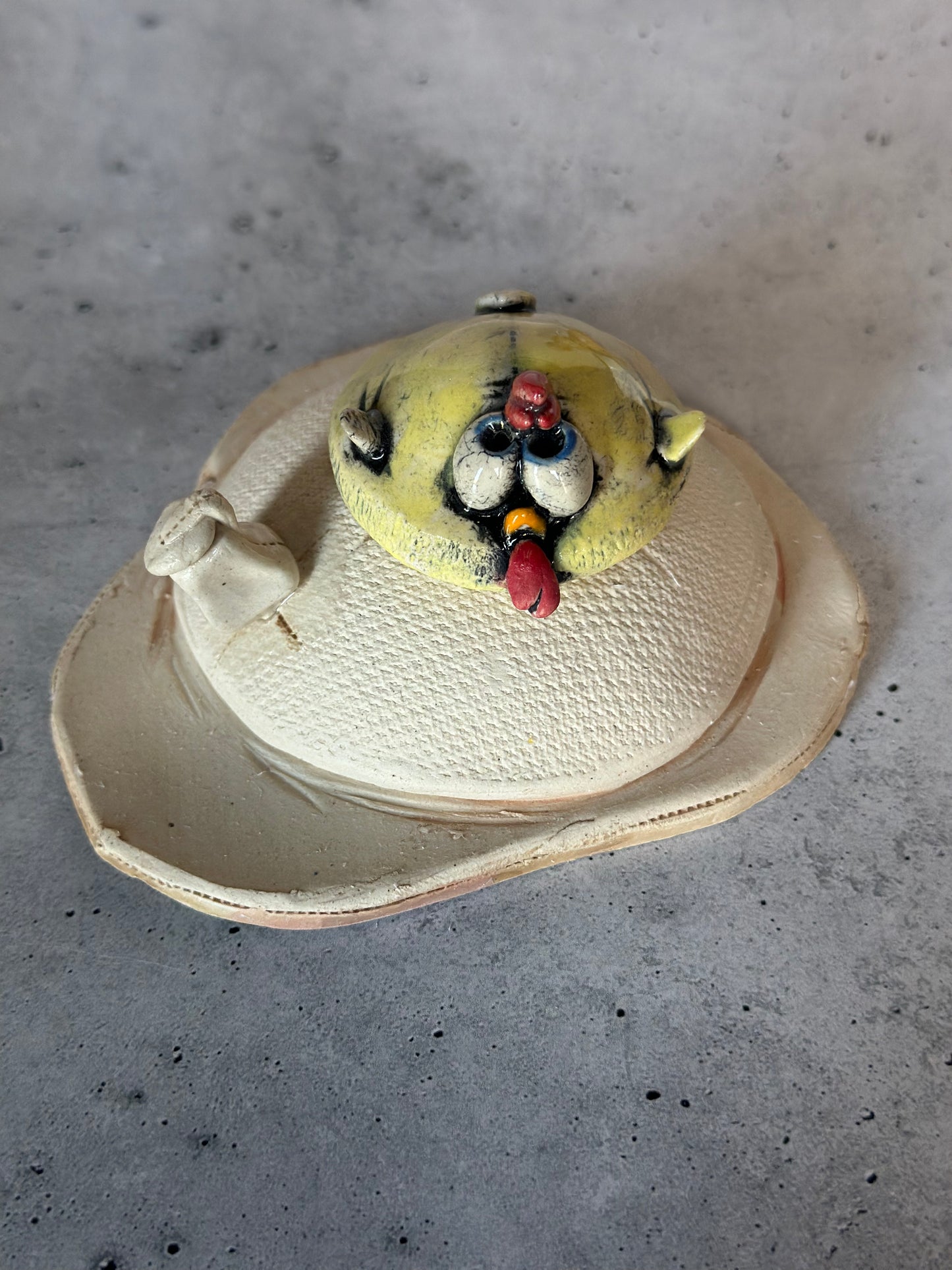 Ceramic chick on egg on a concrete surface