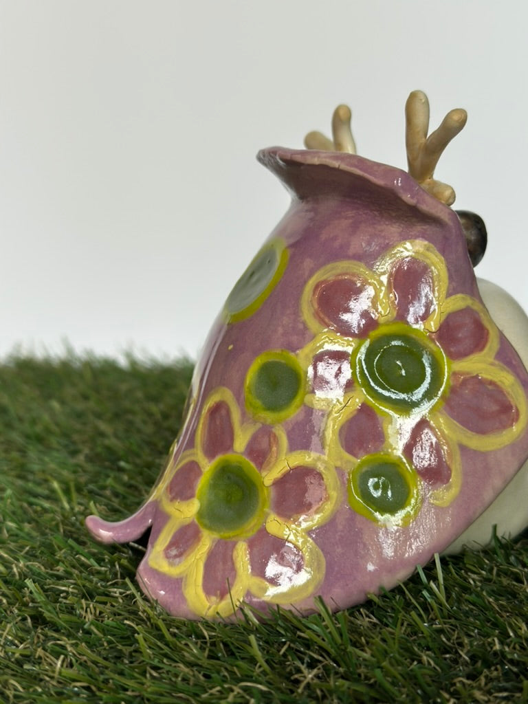 Ceramic tutrix with floral design on a grassy surface