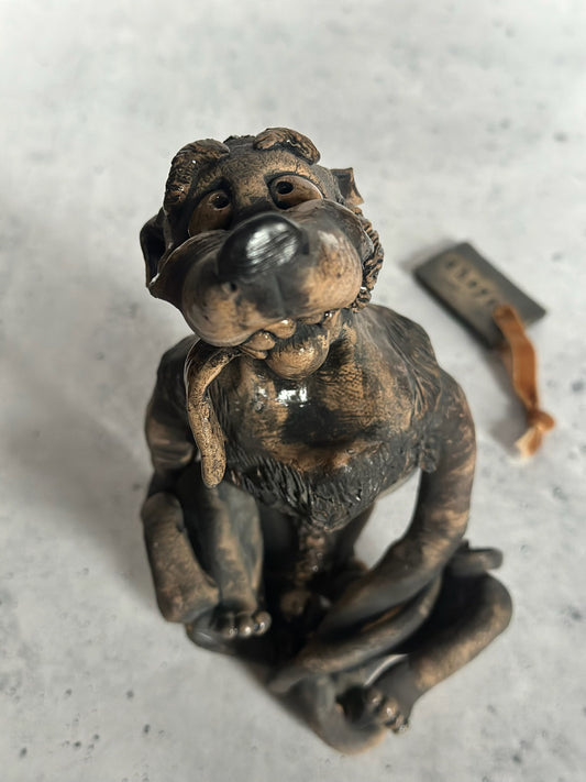 Ceramic statue of a dog on a textured surface