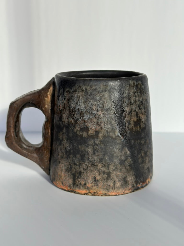 Black ceramic mug with a textured surface on a white background