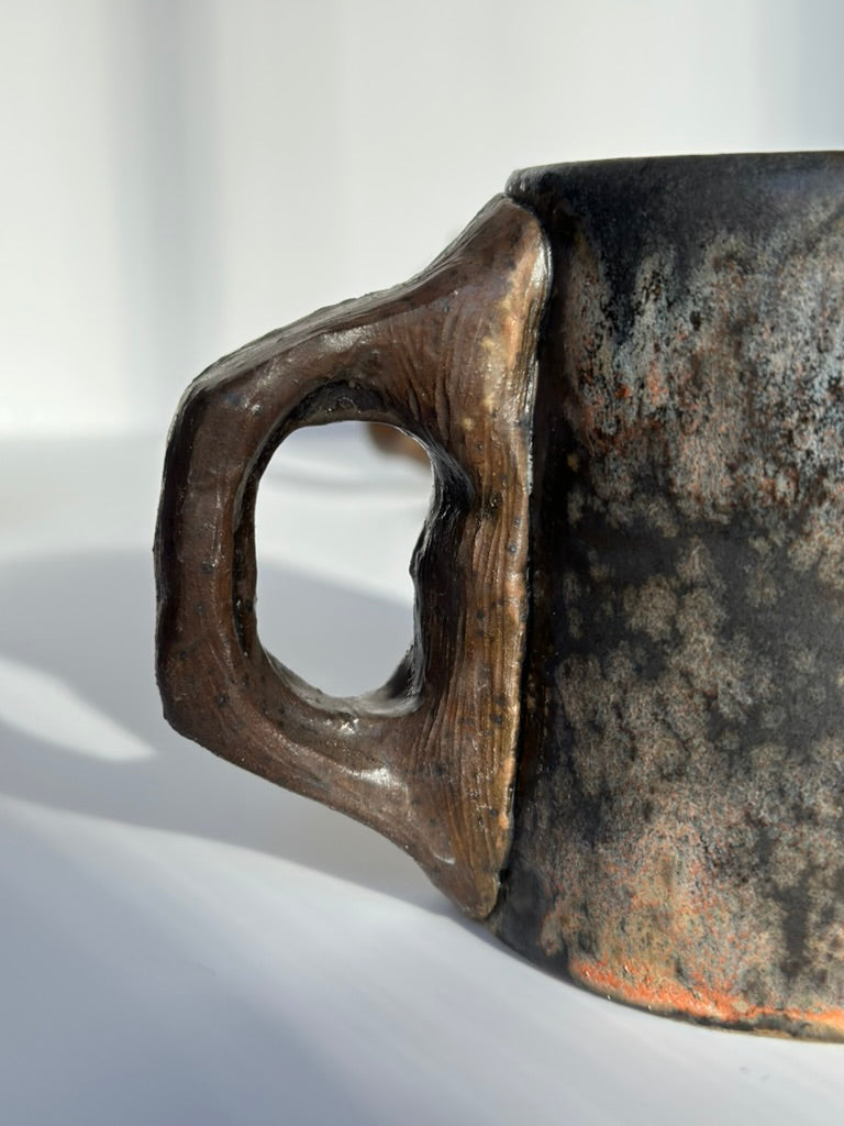 Close-up of a rustic mug handle on a light background